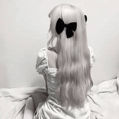 a woman with long white hair and black bows