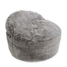 a grey round ottoman sitting on top of a white floor