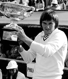 a man holding up a trophy in front of a crowd