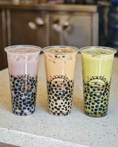 three different colored cups sitting on top of a counter