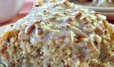 a close up of a piece of cake on a plate with a fork and cup in the background