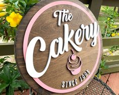 there is a sign that says the cakery and it has a cupcake on it