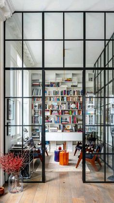 an open room with lots of books on the shelves and glass doors that lead to another room