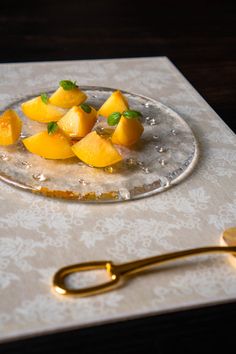 a glass plate topped with sliced mangos on top of a table next to a pair of scissors