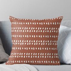 a brown and white pillow sitting on top of a couch