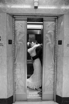 a man and woman are kissing in an elevator with their arms around each other as they kiss