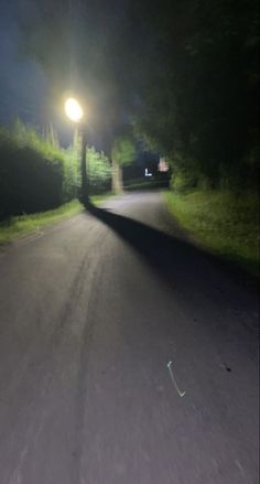 an empty street at night with the light on