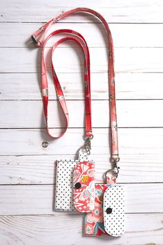 two pieces of paper are attached to a red lanyard with polka dots on it