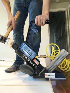 a man using a power drill to fix a piece of wood on top of a table