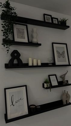 some black shelves with pictures and vases on them