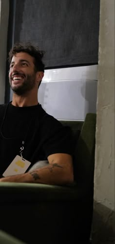 a man sitting in a green chair smiling