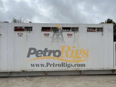 a large white container sitting on top of a dirt field