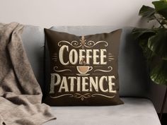 a coffee pillow sitting on top of a gray couch next to a potted plant