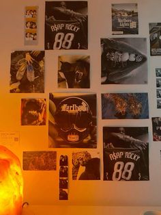 the wall is covered with posters and pictures, including an orange lamp in front of it