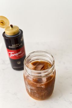 a jar of peanut butter next to a bottle of chocolate