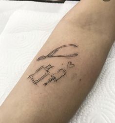 a person with a tattoo on their arm has scissors and a heart in the middle