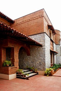 an outside view of a brick building with potted plants