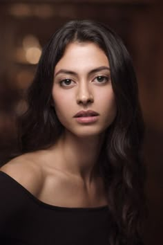 a woman with long dark hair wearing a black top