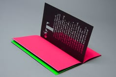 a pink and green folded book on top of each other