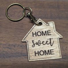 a wooden keychain with the words home sweet home written in black on it