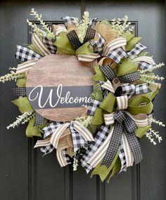 a welcome wreath with green and white ribbons hanging on a door handle that says welcome