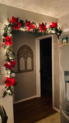 a doorway decorated with christmas garland and poinsettis