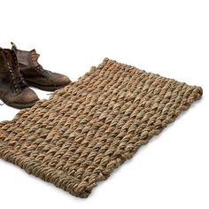 a pair of brown boots sitting on top of a mat