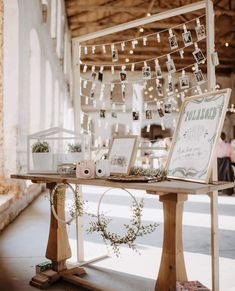 a table with pictures hanging from it and lights strung over the tables in the background