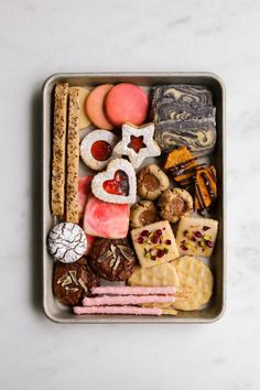 a metal container filled with lots of different types of food on top of a white counter