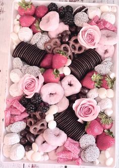 a box filled with lots of different types of doughnuts and strawberries on top of each other