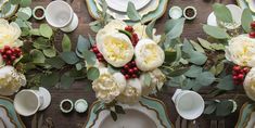 the table is set with flowers and plates