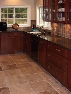 a kitchen with wooden cabinets and tile flooring