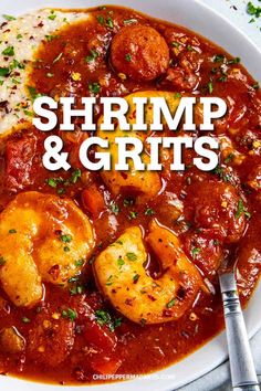 shrimp and grits in a red sauce on a white plate with a fork next to it