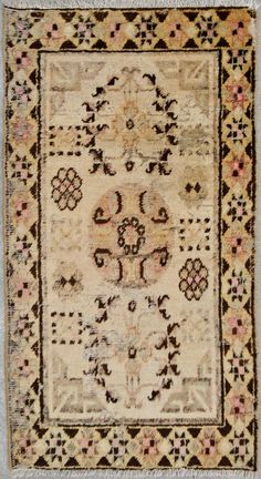 an antique rug is displayed on the floor in front of a white wall and carpet