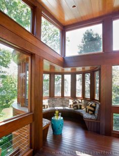 the inside of a house with wood floors and large windows on each side of the room