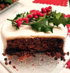 a piece of cake with frosting and holly on top