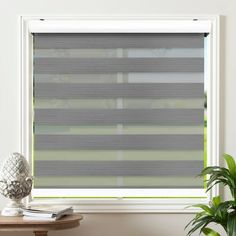 the blinds in this window are made from grey fabric and have horizontal blindes on them