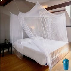 a white bed with mosquito netting over it