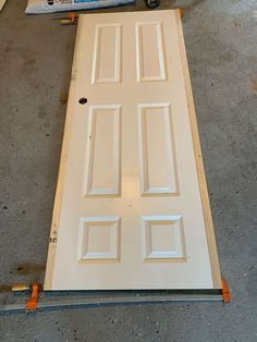 a white door is being installed on the floor