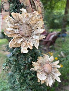 two paper flowers are hanging from a tree