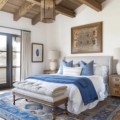 a bedroom with a large bed and blue rugs on the floor next to it