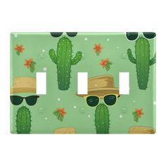 a light switch cover with a cactus pattern and sunglasses on the front, in green