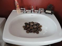 a white bathroom sink with rocks in it