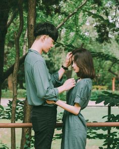 a man and woman standing next to each other in front of trees with text that reads,