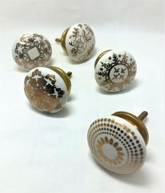 six white and gold cabinet knobs with floral designs on them, all in the same pattern