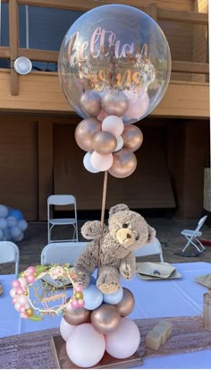 a teddy bear on top of a bunch of balloons in the shape of a balloon