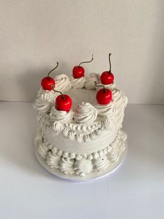 a white cake with cherries on top