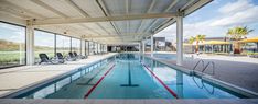 an indoor swimming pool with chairs and umbrellas