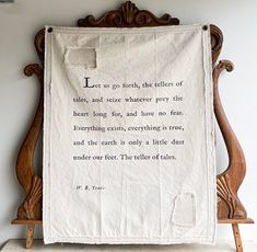 an old wooden chair with a white banner hanging from it's back and some writing on the wall