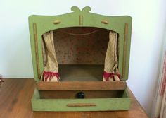 an old fashioned doll house on a wooden table